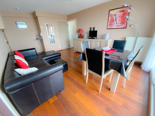 un salon avec un canapé noir et une table dans l'établissement The Beach, à Calais