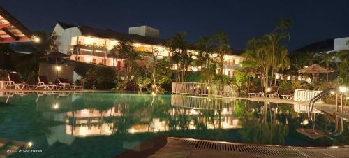 a swimming pool in front of a hotel at night at Phuket Golden Sand Inn - SHA Extra Plus in Karon Beach