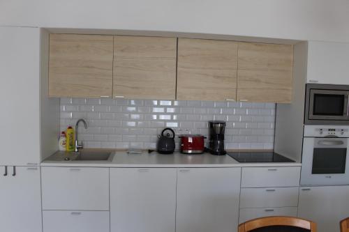 a kitchen with white cabinets and white appliances at Apartmány Stříbro in Stříbro