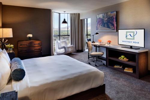 a hotel room with a bed and a desk and a television at Whitney Peak Hotel Reno, Tapestry Collection by Hilton in Reno