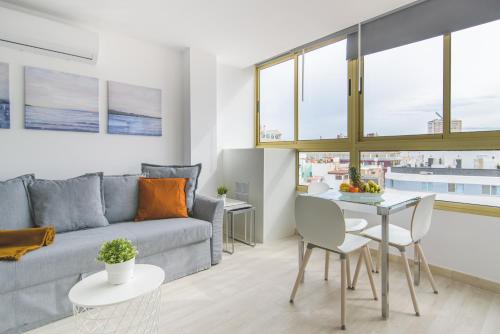 una sala de estar con un sofá y una mesa en Home2Book Stylish Las Canteras3 Beach, en Las Palmas de Gran Canaria