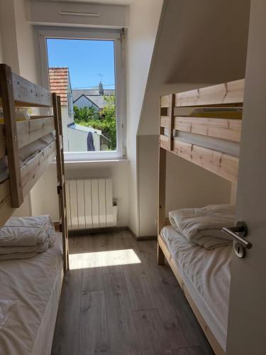 deux lits superposés dans une chambre avec fenêtre dans l'établissement Maison les figuiers Roch Priol, à Quiberon