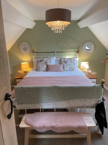 a bedroom with a large bed and a chandelier at Bell Cottage right in the heart of Bridgnorth in Bridgnorth