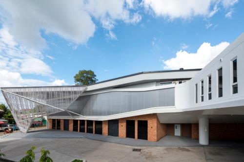 an office building with a metal roof with a white facade at VELA Dhi Udon Thani in Udon Thani