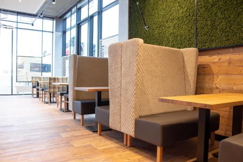a row of tables and chairs in a restaurant at Kedi Hotel Papenburg in Papenburg
