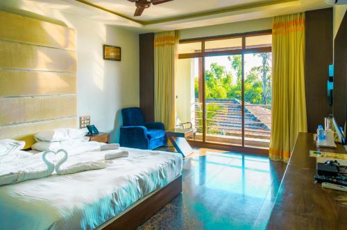 戈卡尔纳Kudle Beach View Resort And Spa Gokarna的一间卧室，里面有一张床、一把椅子和一扇窗户