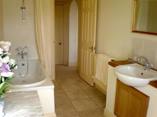 a bathroom with a sink and a tub next to a sink at Higher Faugan Parc in Penzance