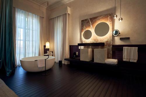 马略卡岛帕尔马Can Bordoy Grand House Hotel GL Preferred Hotel的带大浴缸和大镜子的浴室