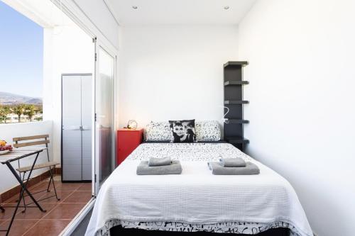a bedroom with a large bed in a room with a table at Home2Book Stylish Studio Costa del Silencio in Costa Del Silencio