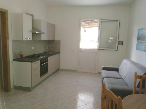 uma cozinha e sala de estar com um sofá e uma mesa em SALINA APPARTAMENTI em Trapani