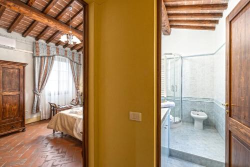 ein Schlafzimmer mit einem Bett und ein Badezimmer in der Unterkunft Dimora di Castroncello in Castiglion Fiorentino