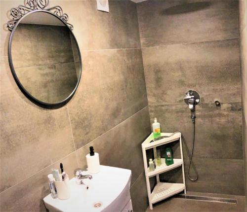 uma casa de banho com um lavatório e um espelho em Pērle em Ragaciems