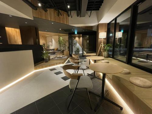 a lobby with tables and chairs in a building at R Hotel Namba in Osaka