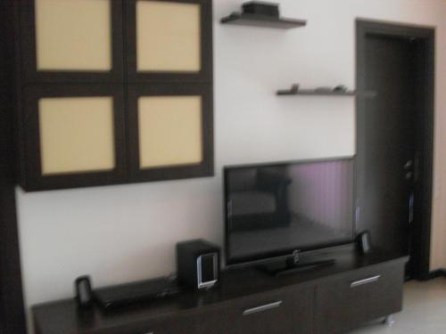 a living room with a flat screen tv on a cabinet at Apartamente Neptun Bosco in Neptun