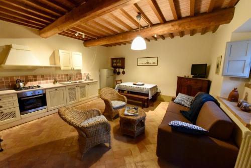 a living room with a couch and chairs and a kitchen at Piccolo Borgo Gagnoni in Sinalunga