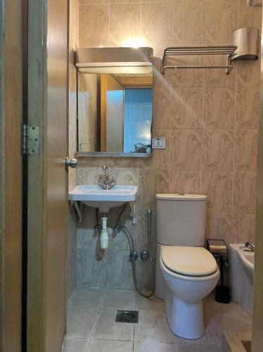 a bathroom with a toilet and a sink at شقق منصور بلازا للشقق المخدومة in Dammam