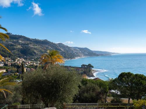 Blick auf einen Strand mit einer Palme und das Meer in der Unterkunft Apartment Belvedere by Interhome in Mortola Inferiore