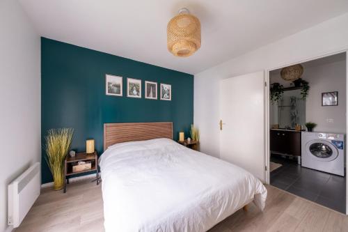 ein Schlafzimmer mit einem Bett und einer blauen Wand in der Unterkunft Sérénité proche Disneyland in Serris