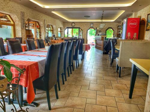a dining room with tables and chairs in a restaurant at Hotel Zéta in Lenti