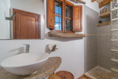 ein Badezimmer mit einem weißen Waschbecken und einer Dusche in der Unterkunft Can Grever in Llubí