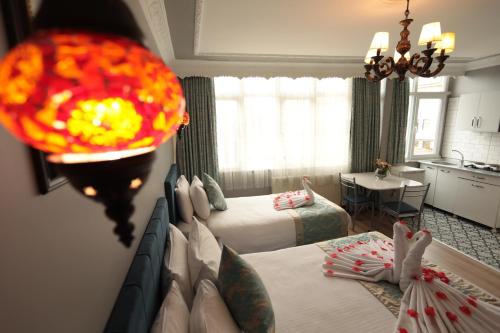 a hotel room with two beds and a chandelier at White Pearl Apart Hotel in Istanbul