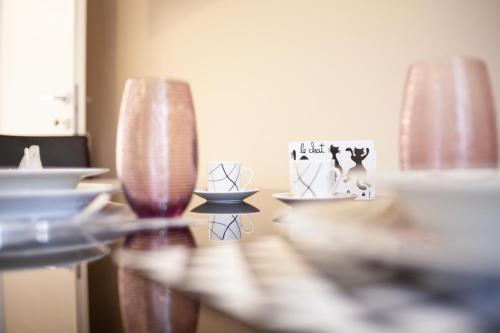een tafel met twee vazen en kommen erop bij Lambrate Elegant Bright Apartment in Milaan