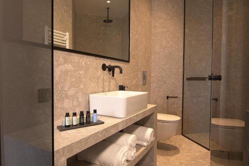 a bathroom with a sink and a toilet at Cityzoe Athens Suites in Athens