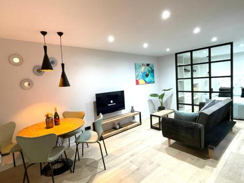 ein Wohnzimmer mit einem Tisch, einem Sofa und einem TV in der Unterkunft ALANDA vivienda turística in Burgos