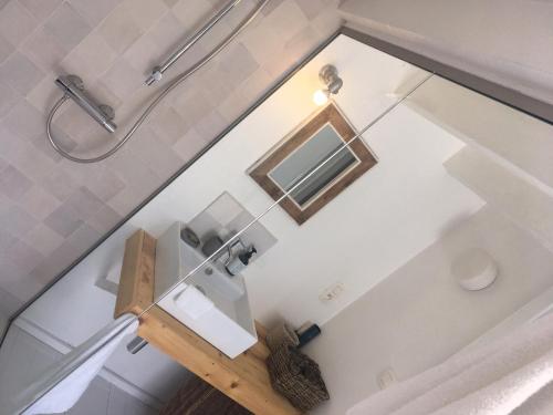 ein Badezimmer mit einem Spiegel und einem Waschbecken in der Unterkunft Domus Damme in Damme
