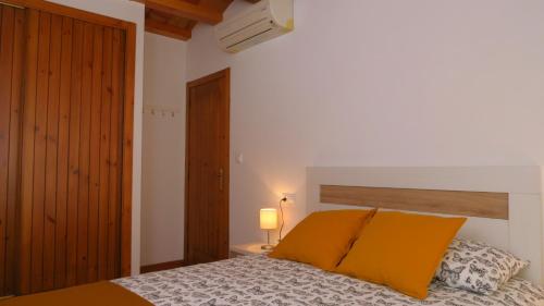 - une chambre dotée d'un lit avec des oreillers orange dans l'établissement APARTAMENT VALL D´EBO, à Vall de Ebo