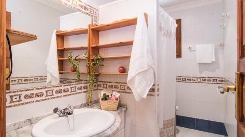 a white bathroom with a sink and a shower at Finca Es Revolt de Sa Barrala in Campos