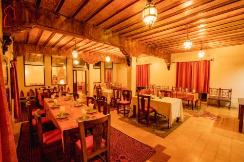Riad Mamouche في مرزوقة: غرفة طعام كبيرة مع طاولات وكراسي