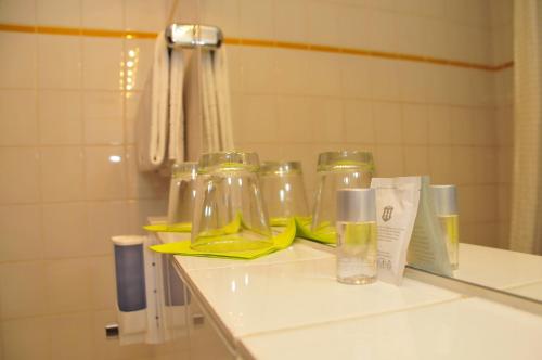 a bathroom counter with three glass jars on it at Hotel zum Brunnen in Friedberg