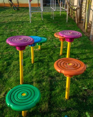 a group of colorful stools sitting in the grass at Hotel Sonar Bangla Tarapith in Tarapith