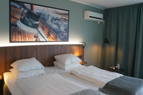 a bedroom with a white bed with a picture on the wall at Best Western Hotel Corallen in Oskarshamn