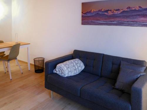 a living room with a blue couch and a table at Apartment Schwendi 3 by Interhome in Grindelwald