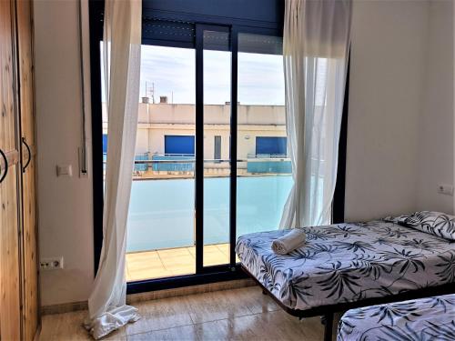 a bedroom with a bed and a view of a pool at Mar del Delta in L'Ampolla