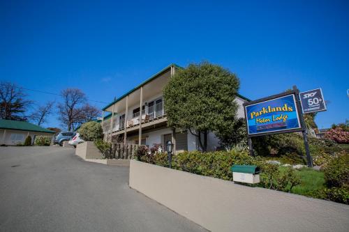 a sign for a restaurant in front of a building at Parklands Motor Lodge Timaru in Timaru