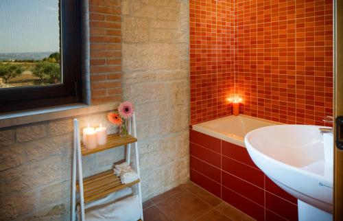 a red tiled bathroom with a sink and a tub at Borgo Olivo in Pietrelcina