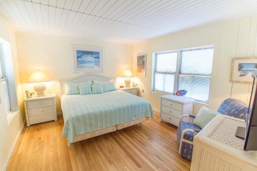 a white bedroom with a bed and a chair at Hunter's Haven, 2 Bedrooms, Sleeps 6, Ocean Front, Pet Friendly in Crescent Beach