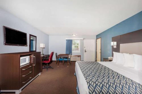 una grande camera d'albergo con letto e scrivania di Days Inn by Wyndham Austin/University/Downtown ad Austin