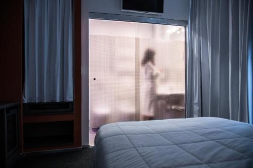 a person is standing in a bedroom with a bed at Executive Inn Boutique Hotel in Brindisi