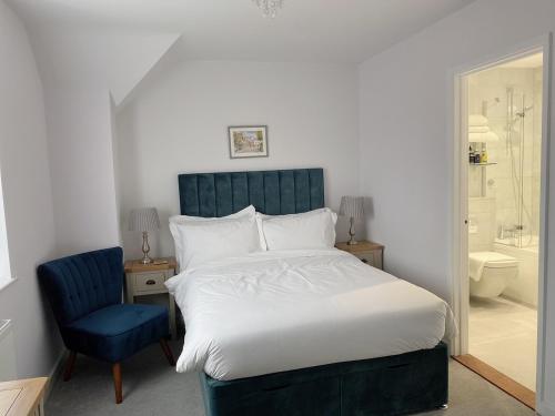 um quarto com uma cama grande e uma cadeira azul em Prestbury Bed & Breakfast em Salisbury