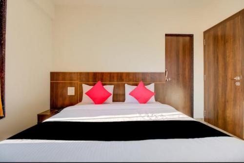 a bedroom with a large bed with pink pillows at Hotel rio inn in Trimbak