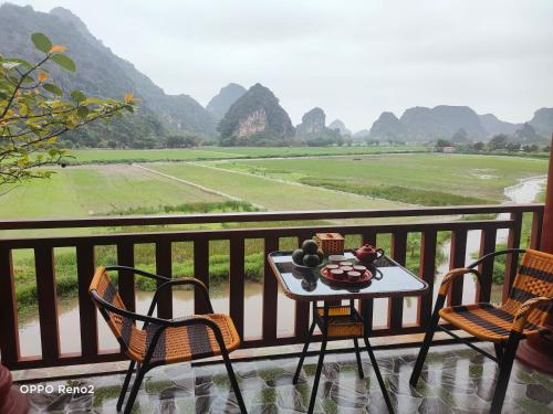 a table and chairs on a balcony overlooking a valley at Trang An Tam Gia Trang Resort in Ninh Binh