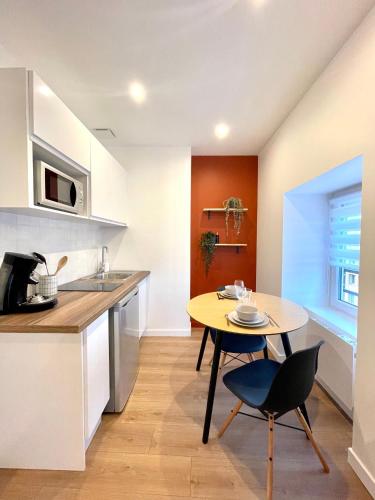 - une cuisine avec une table, une petite table et des chaises dans l'établissement L'Arizona, à Saint-Étienne