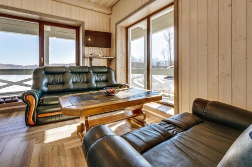 a living room with leather furniture and a table at Kaimo turizmo sodyba „Šerno slėnis“ in Vėdariai