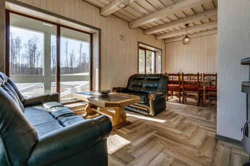 a living room with leather furniture and a table at Kaimo turizmo sodyba „Šerno slėnis“ in Vėdariai
