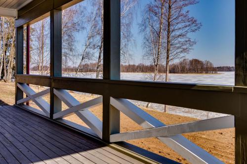 a window on a porch looking out at a lake at Kaimo turizmo sodyba „Šerno slėnis“ in Vėdariai