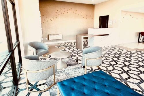a lobby with chairs and a piano in a room at Ramada by Wyndham Modesto Yosemite Area in Modesto